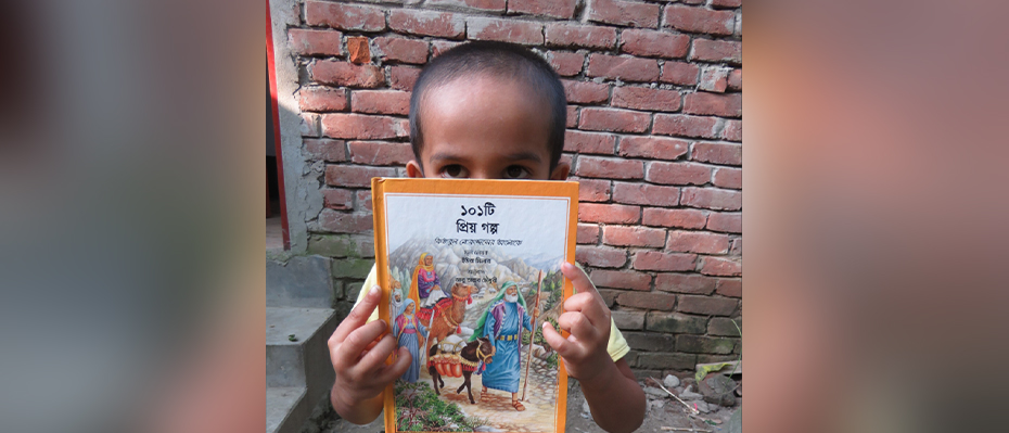 Jahangir (four years old) from Bangladesh holds up his Bible to the camera