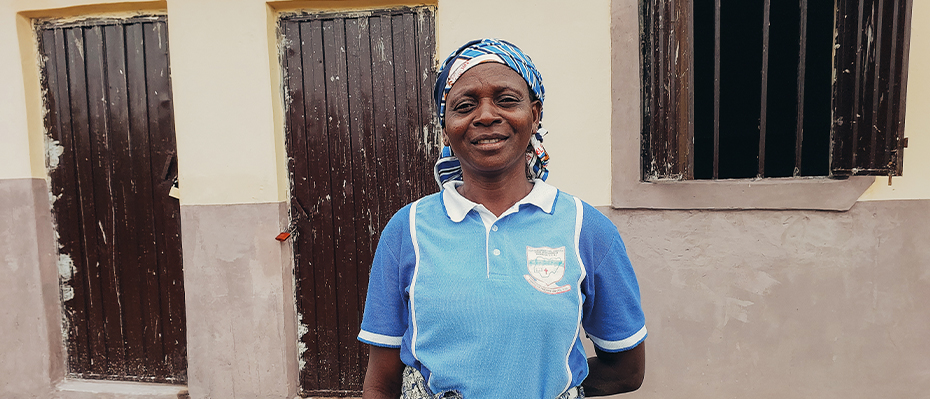 Bethany from Nigeria stands and smiles outside her new home which was built with help from Open Doors supporters.